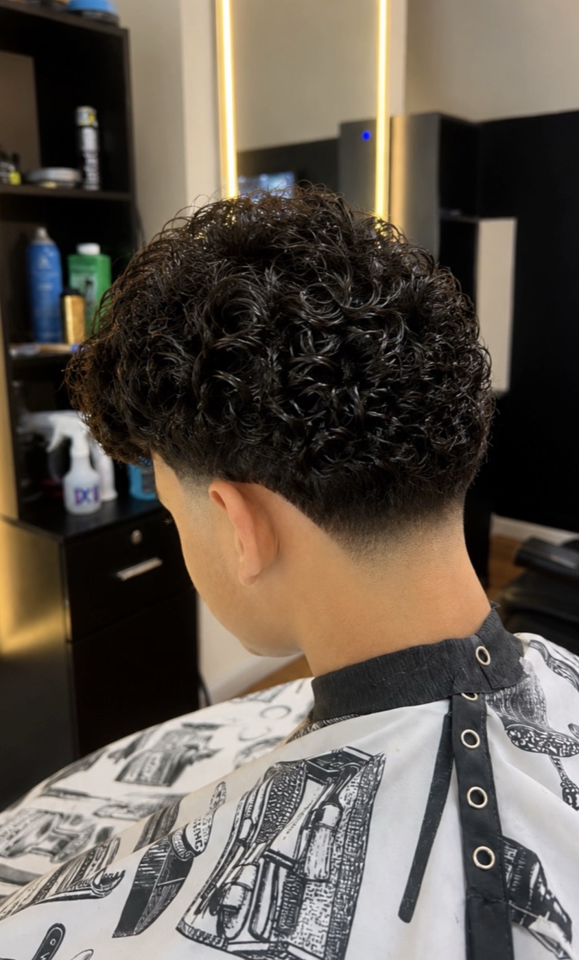 Textured curly fade with a clean low taper